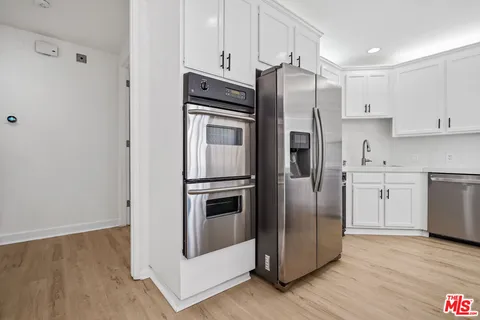 a kitchen with stainless steel appliances a refrigerator sink and cabinets