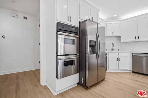 a kitchen with stainless steel appliances a refrigerator sink and cabinets