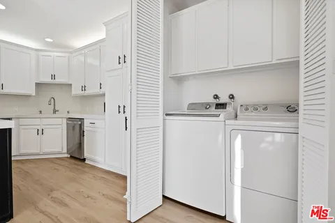 a utility room with cabinets washer and dryer