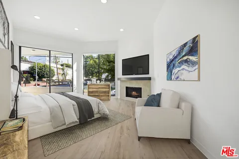 a spacious bedroom with a bed and a flat screen tv