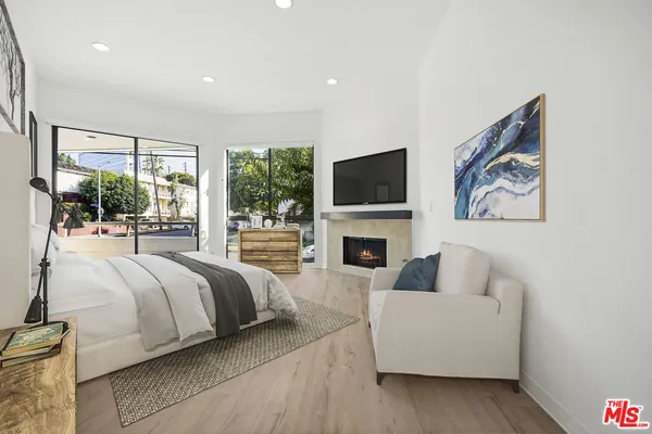 a spacious bedroom with a bed and a flat screen tv