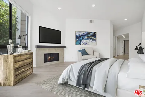 a spacious bedroom with a large bed and a fireplace