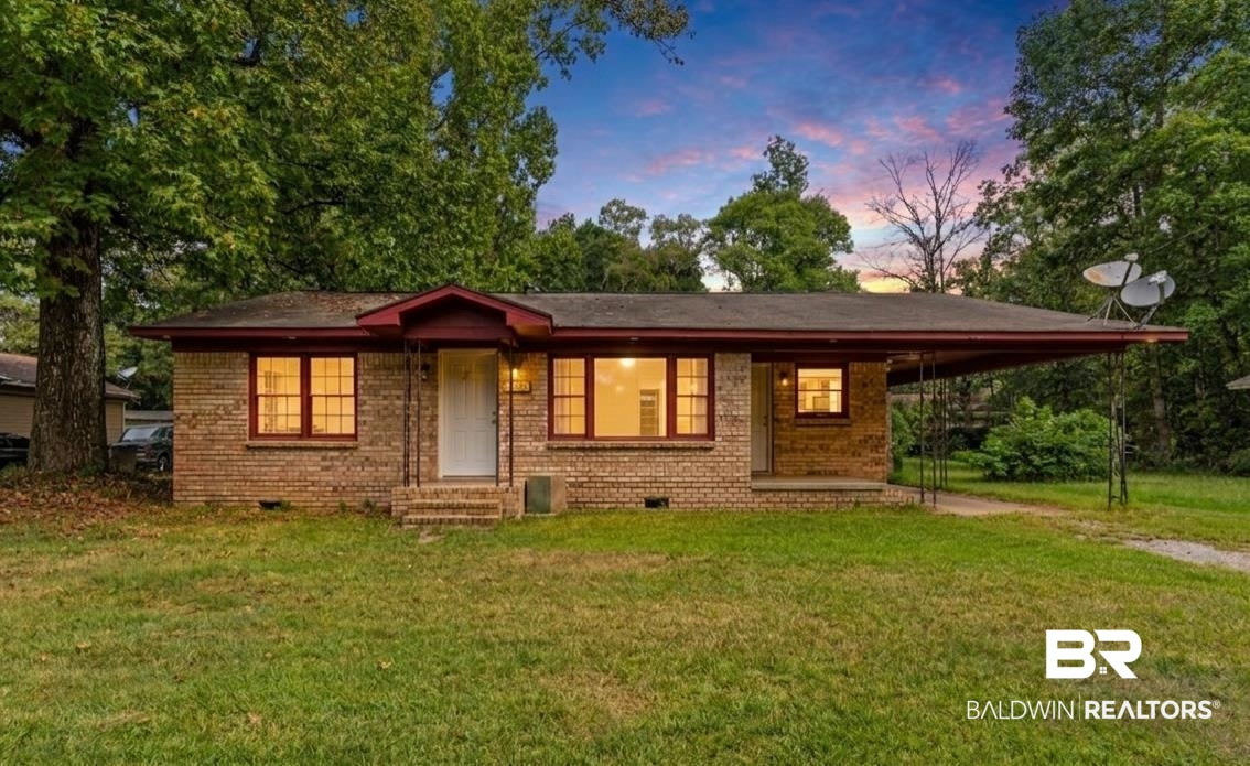 1550 Lartigue Avenue South Mobile, AL 36605 - Photo 1 of 22 Brick exterior residence with a covered entryway, a carport, and mature trees on the property