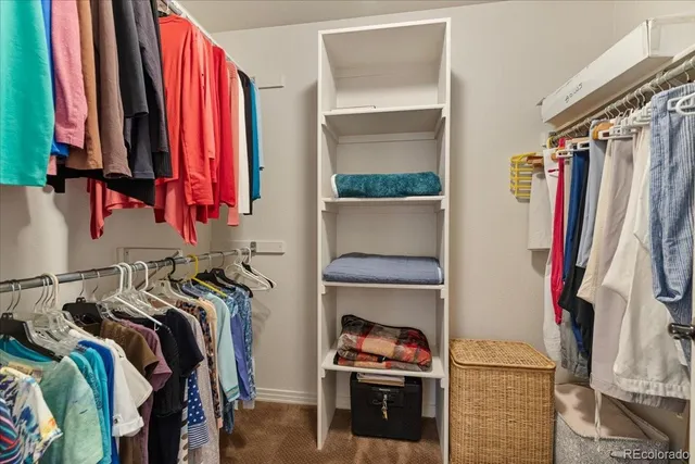 a view of walk in closet with clothes and shoes