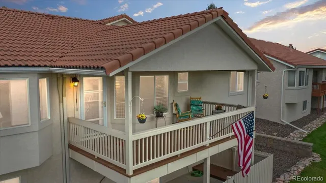 a porch with a bench next to a yard