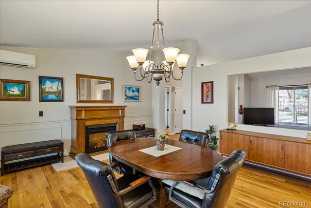 a dining room with wooden floor and a chandelier