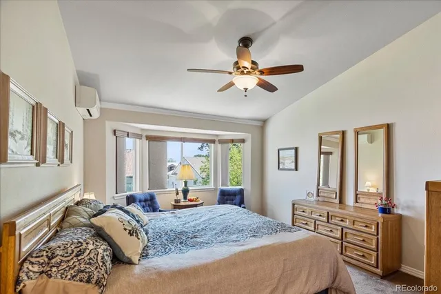 a bedroom with a large bed a chandelier and dresser