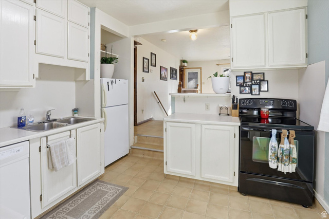 380 North 200 West Logan, UT 84321 - Photo 7 of 29 Kitchen with white appliances, white cabinets, light countertops, and a peninsula