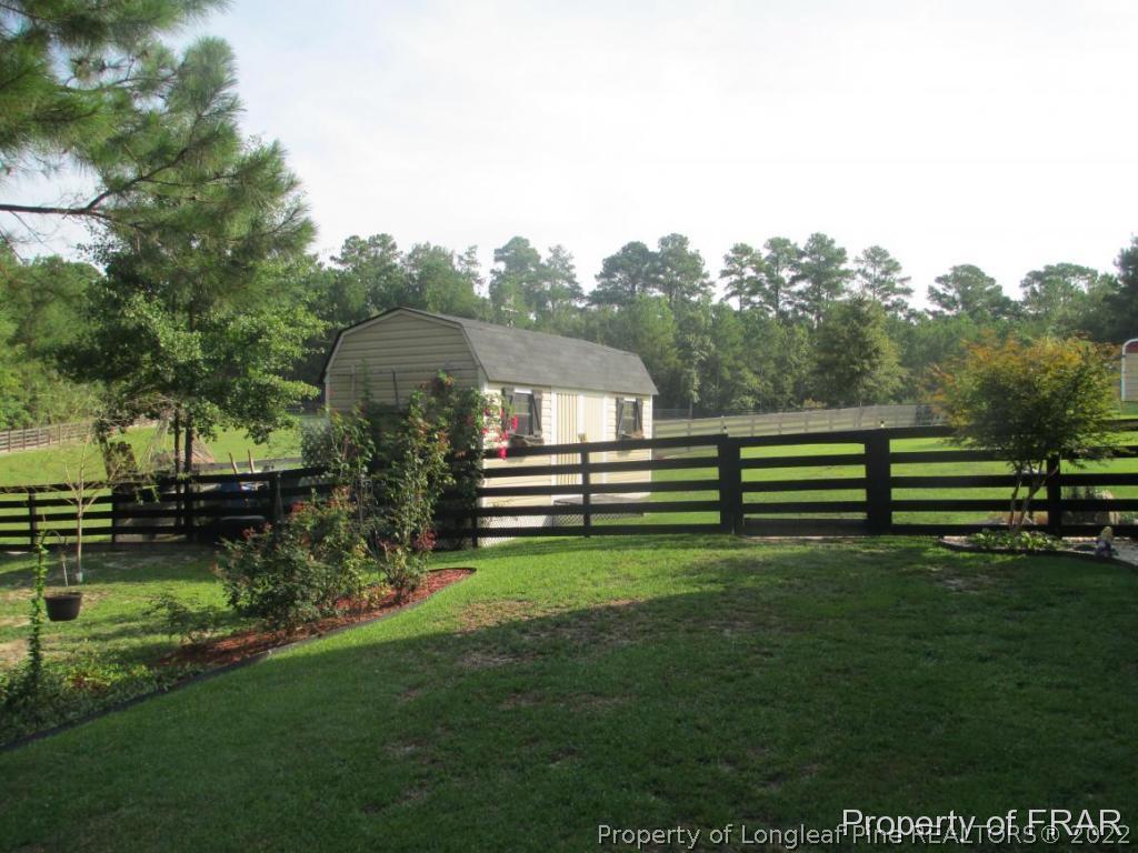 5028 Aberdeen Road Raeford, NC 28376 - Photo 30 of 34 a view of a house with a backyard and trees