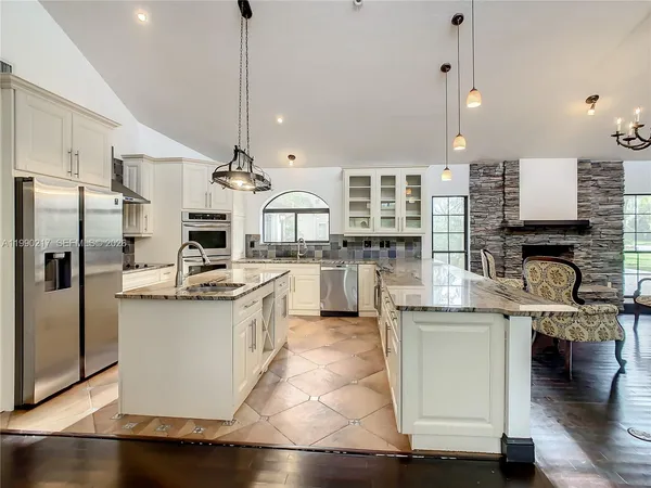 a large kitchen with stainless steel appliances granite countertop a lot of counter space
