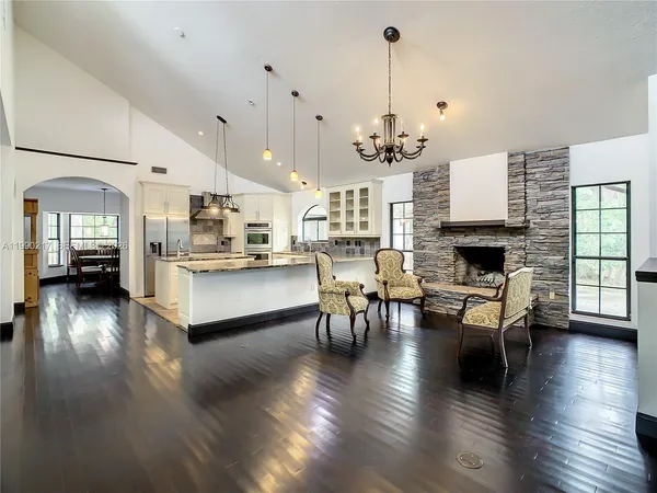 a living room with furniture wooden floor and a large window
