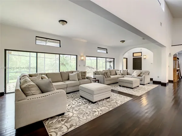 a living room with furniture and view of kitchen