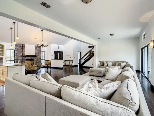 a large kitchen with kitchen island a large counter top stainless steel appliances and cabinets