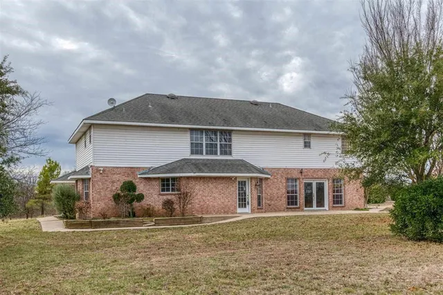 an empty room with windows and ceiling fan