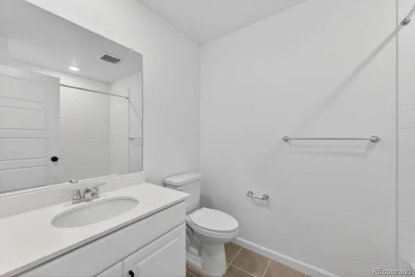 a bathroom with a granite countertop sink toilet and a mirror