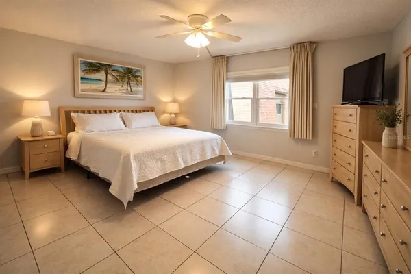 a large white bed in a bedroom next to a lamp