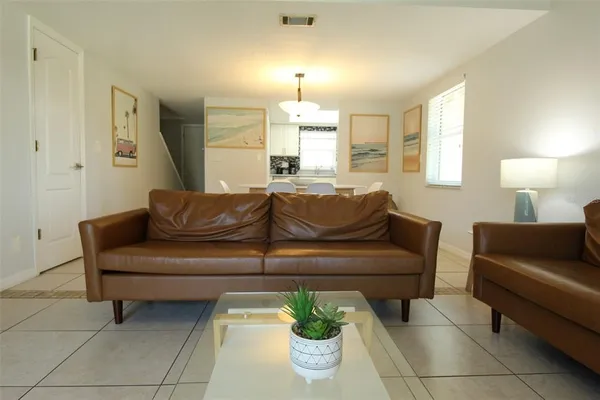 a living room with furniture and a chandelier