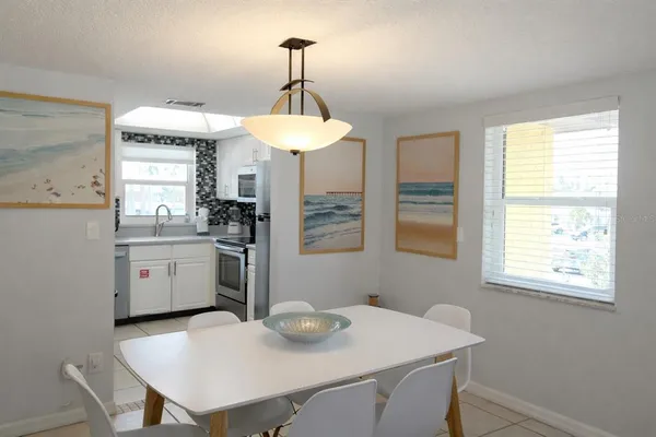 a kitchen with a table chairs a sink and dishwasher
