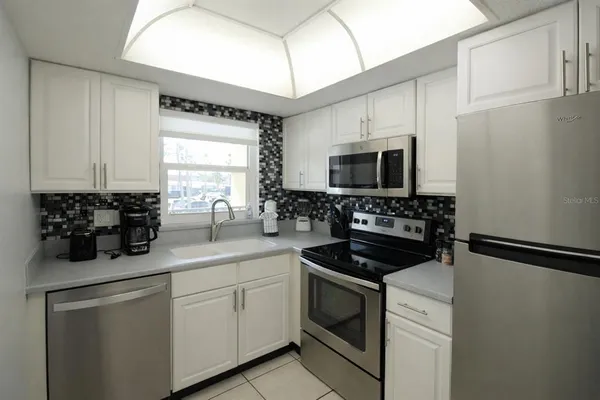 a kitchen with a sink stove and microwave
