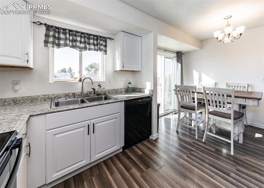 9765 Wineglass Road Fountain, CO 80817 - Photo 12 of 37 a kitchen with a table chairs cabinets and wooden floor