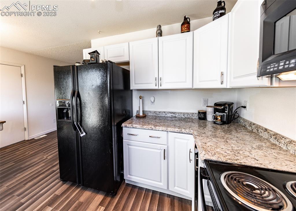 9765 Wineglass Road Fountain, CO 80817 - Photo 13 of 37 a kitchen with a refrigerator sink and cabinets