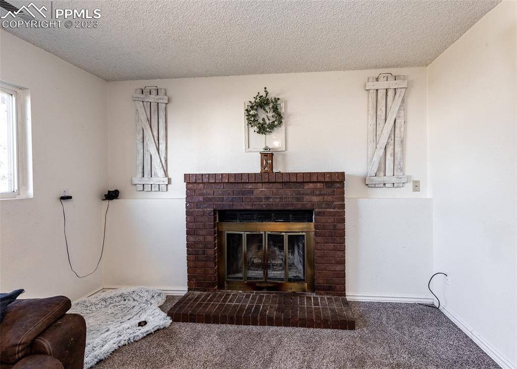 9765 Wineglass Road Fountain, CO 80817 - Photo 17 of 37 a living room with furniture and a fireplace