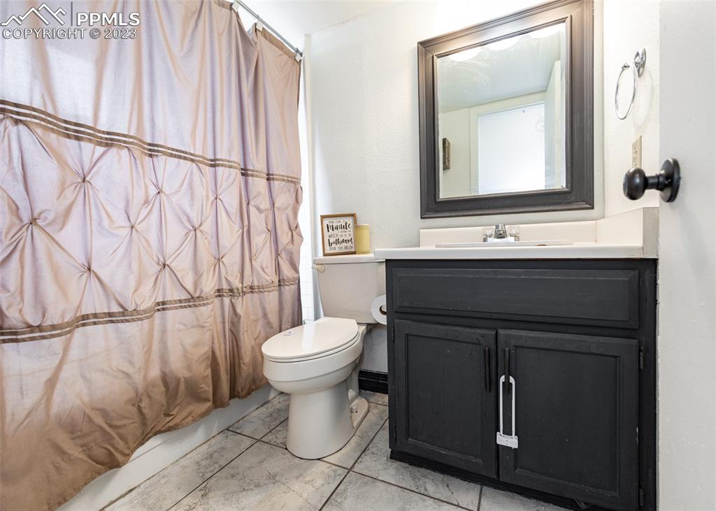 9765 Wineglass Road Fountain, CO 80817 - Photo 21 of 37 a bathroom with a toilet sink and mirror
