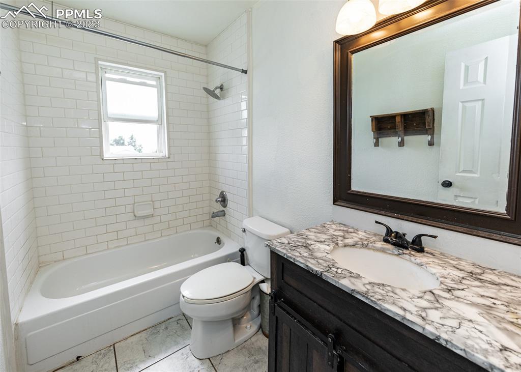 9765 Wineglass Road Fountain, CO 80817 - Photo 23 of 37 a bathroom with a granite countertop sink a toilet a mirror and bathtub