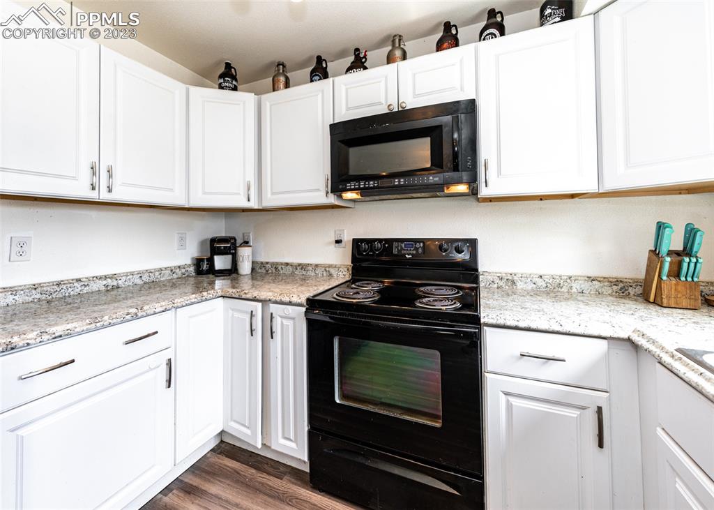 9765 Wineglass Road Fountain, CO 80817 - Photo 9 of 37 a kitchen with stainless steel appliances granite countertop white cabinets granite counter tops and a hard wood floors
