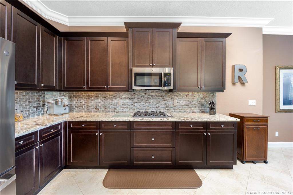 6863 Southeast Pierre Circle Stuart, FL 34997 - Photo 17 of 39 a kitchen with granite countertop a sink and a stove