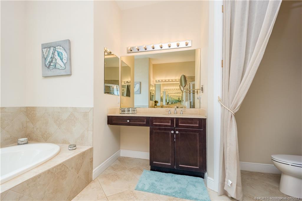 6863 Southeast Pierre Circle Stuart, FL 34997 - Photo 24 of 39 a spacious bathroom with a bathtub sink and mirror