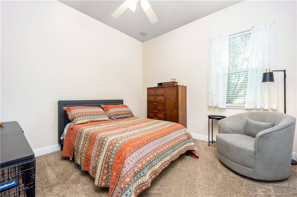 6863 Southeast Pierre Circle Stuart, FL 34997 - Photo 27 of 39 a bedroom with a bed and a couch