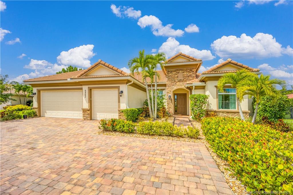 6863 Southeast Pierre Circle Stuart, FL 34997 - Photo 7 of 39 a front view of a house with a yard