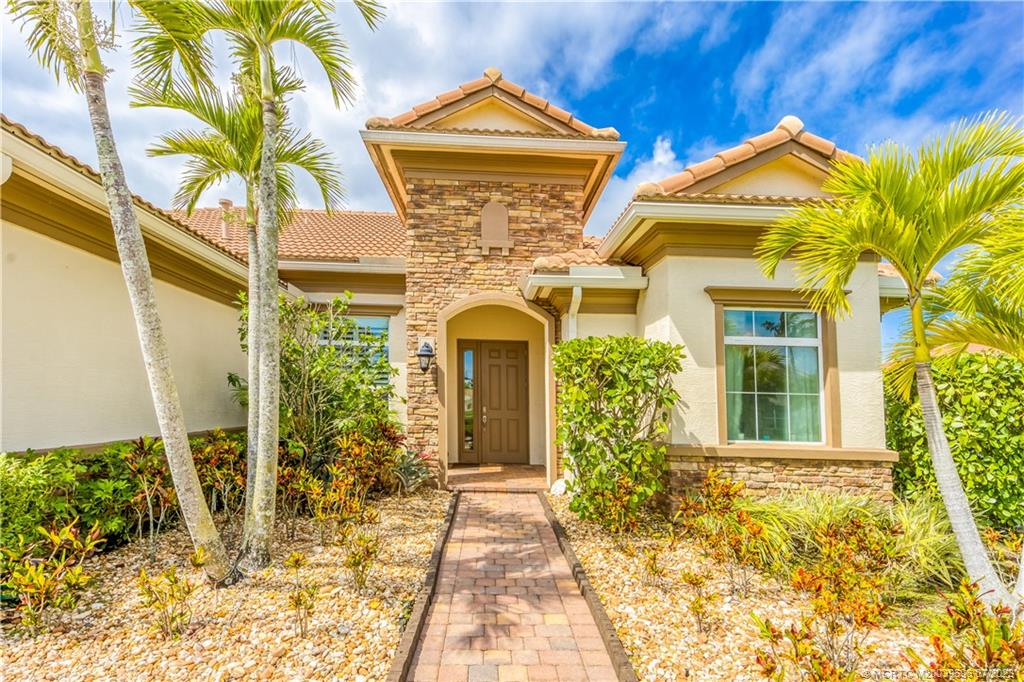 6863 Southeast Pierre Circle Stuart, FL 34997 - Photo 8 of 39 a view of a house with brick walls and potted plants
