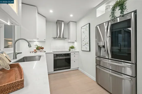 a kitchen with stainless steel appliances granite countertop a refrigerator sink and stove