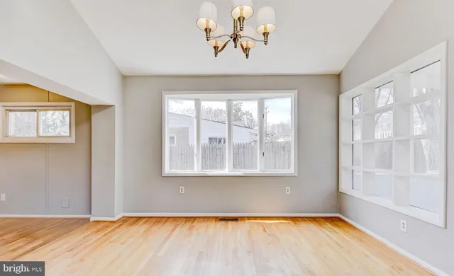 a view of a room with window wooden floor and front door