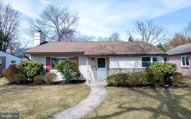 a front view of a house with a yard and potted plants