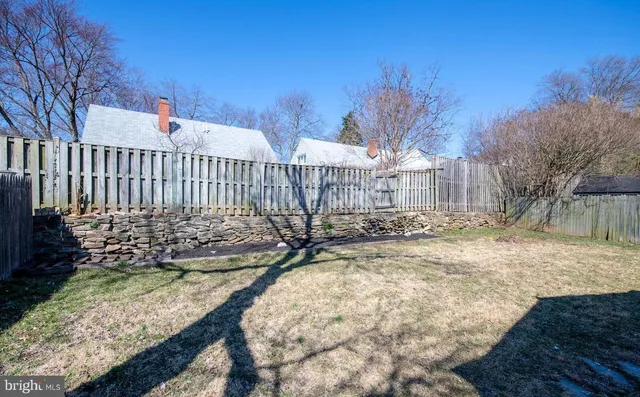 a view of a yard with wooden fence