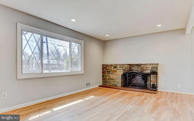 an empty room with a fireplace and windows
