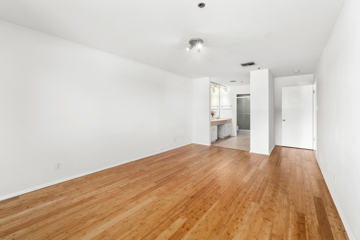 40 North Interstate Highway 35, Unit 3D3 Austin, TX 78701 - Photo 15 of 40 a view of empty room with wooden floor and kitchen