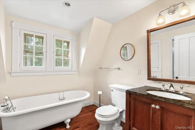 a bathroom with a granite countertop toilet a sink and a bathtub
