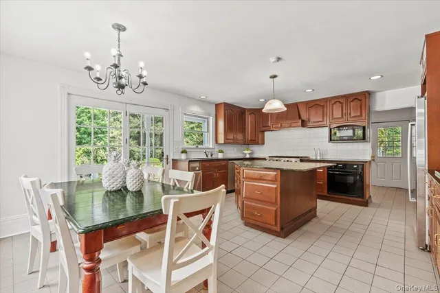 a kitchen with stainless steel appliances granite countertop a stove a sink dishwasher and a wooden cabinets