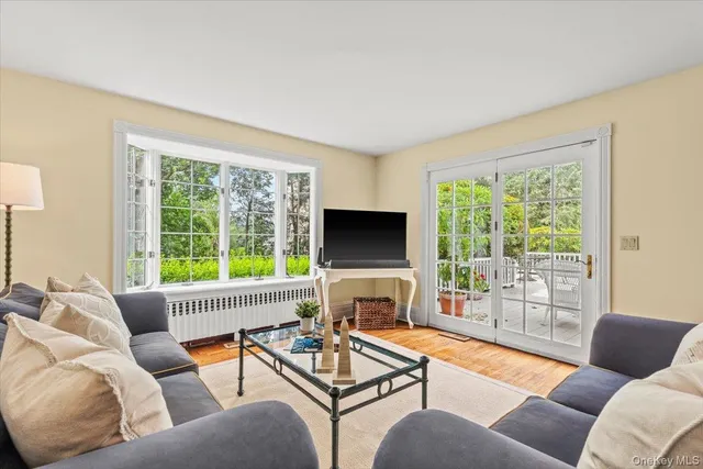 a living room with furniture a flat screen tv and a large window