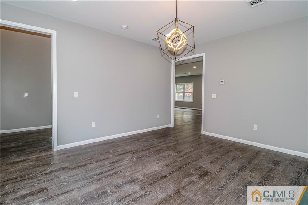 6 Dayton Road Edison, NJ 08817 - Photo 12 of 38 an empty room with wooden floor and a hallway