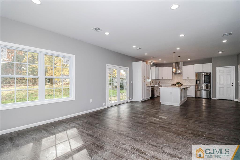 6 Dayton Road Edison, NJ 08817 - Photo 19 of 38 a view of an empty room with wooden floor and a kitchen