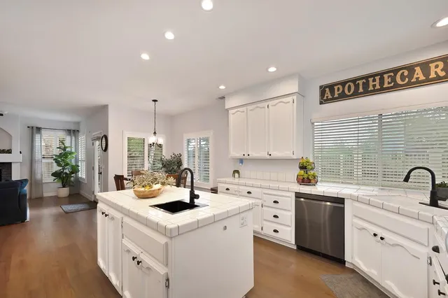 a kitchen that has a sink and a stove with wooden floor