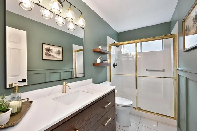 a bathroom with a granite countertop sink toilet and shower