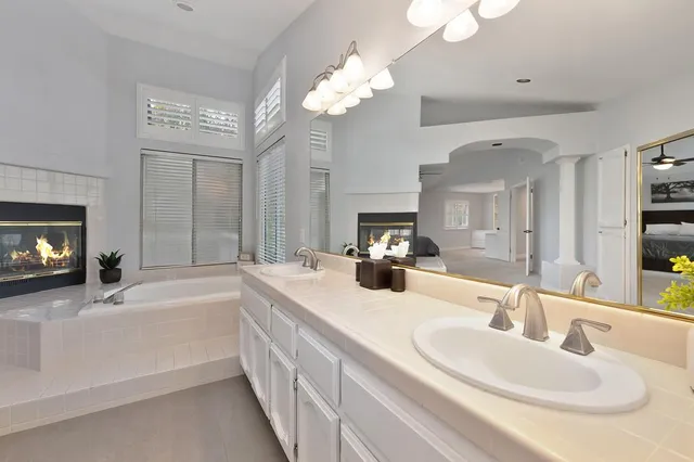 a bathroom with a sink a large mirror and a bathtub