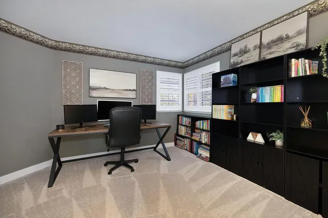 a work room with furniture a bookshelf and a flat screen tv