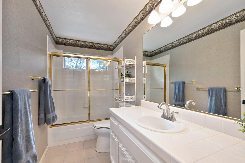 113 Ballast Way Folsom, CA 95630 - Photo 30 of 42 a bathroom with a granite countertop sink a toilet a mirror and shower